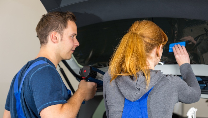 Mechanic tinting car window with tinted foil or film